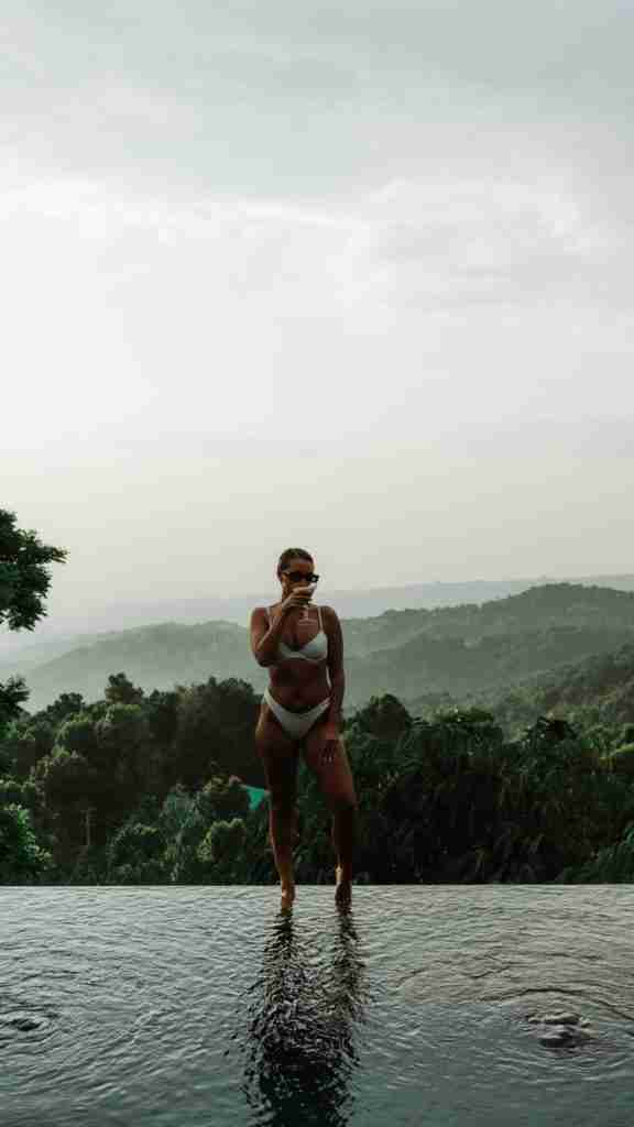 Girl sipping an espresso martini by the pool at Munduk Cabins, Bali — a stylish jungle escape featured on Bohemian Bela.