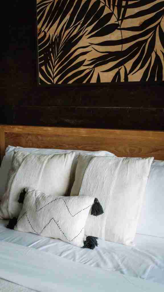 Soft, layered bedding at Munduk Cabins with neutral tones and cozy textures — a restful room setup featured on Bohemian Bela.